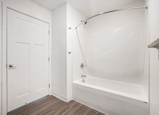 a white bathroom with a shower and a tub  at Signature Pointe Apartment Homes, Alabama