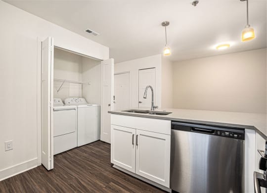 a kitchen with a washer/dryer and a stainless steel dishwasher  at Signature Pointe Apartment Homes, Athens