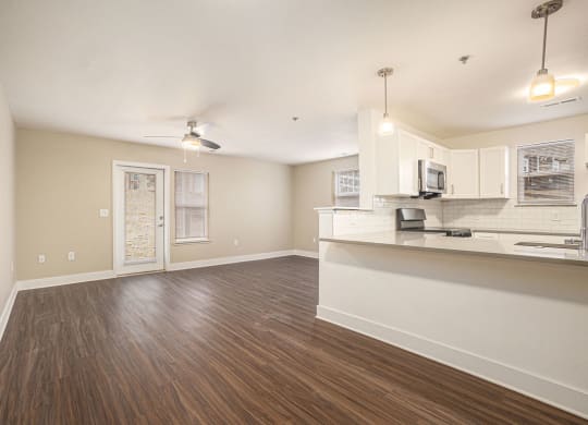 End living room and kitchen with wood floors  at Signature Pointe Apartment Homes, Alabama