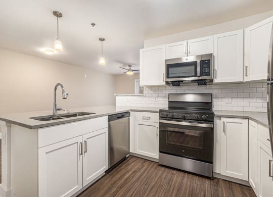 a kitchen with white cabinets and stainless steel appliances  at Signature Pointe Apartment Homes, Athens, AL