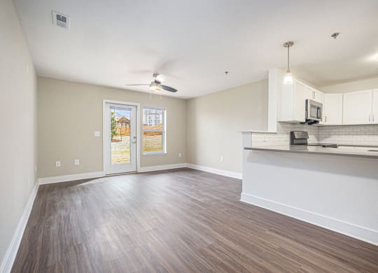 spacious living room and kitchen with a door to a private patio  at Signature Pointe Apartment Homes, Alabama, 35611