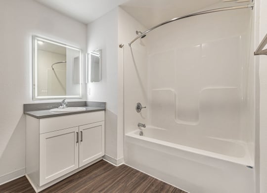 a bathroom with a shower and a sink and a mirror  at Signature Pointe Apartment Homes, Athens, Alabama