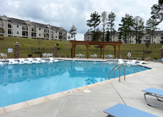 a swimming pool with large sundeck and plenty of seating areas at Signature Pointe Apartment Homes, Athens, AL