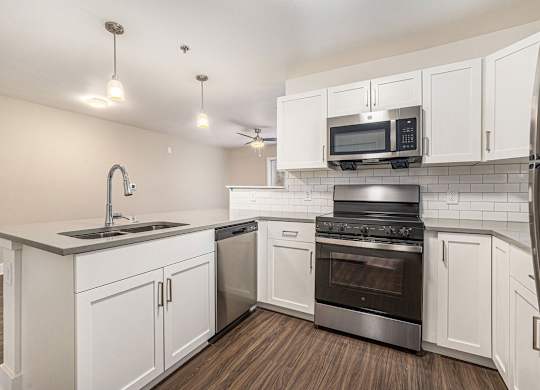A kitchen with white cabinets and a stainless steel stove at Signature Pointe Apartment Homes, Athens, 35611