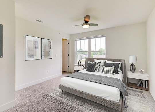 A bedroom with a large bed and a ceiling fan at Signature Pointe Apartment Homes, Athens