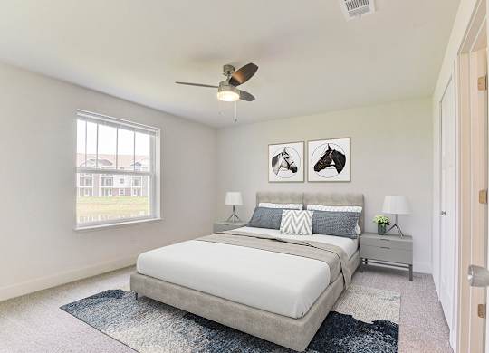 A bedroom with a bed, nightstands, a window and a ceiling fan at Signature Pointe Apartment Homes, Athens