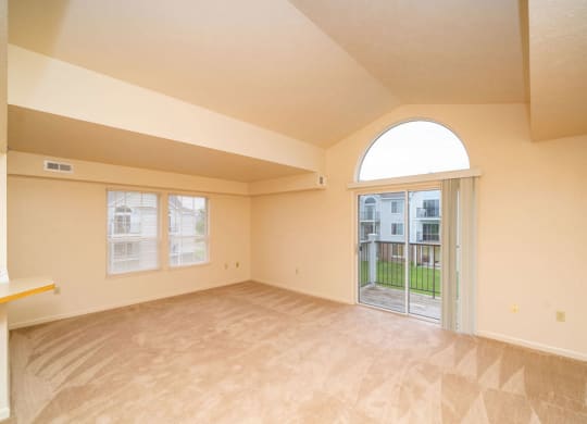end style living room with a sliding glass door to a balcony at South Bridge Apartments in Fort Wayne, Indiana