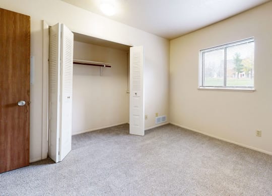 bedroom with a large closet and a window at South Bridge Apartments in Fort Wayne, Indiana