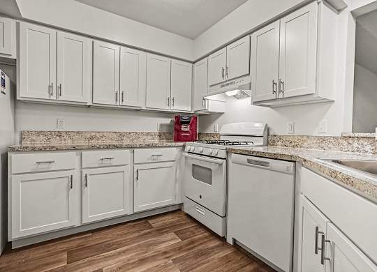 A kitchen with white cabinets and appliances.