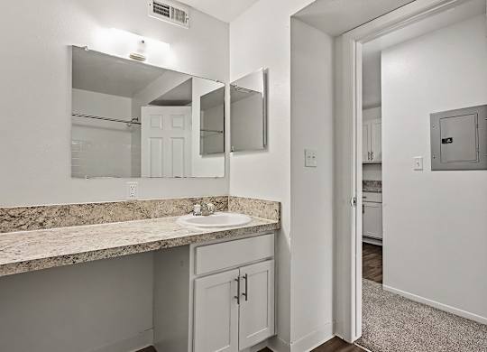A bathroom with a sink, mirror, and medicine cabinet.
