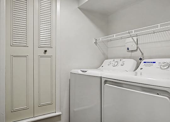 A white washing machine and dryer in a laundry room.