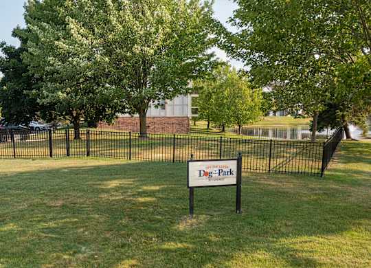A sign in a grassy area that says Dog Park.