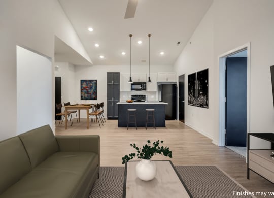 a living room with a couch and a table with chairs in front of a kitchen with a  at Uptown Square Apartments, Michigan, 48083