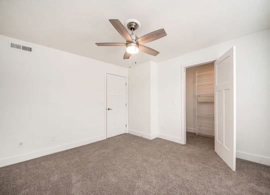 Carpeted bedroom with a ceiling fan and a closet at Stoney Pointe Apartment Homes, Wichita, 67226