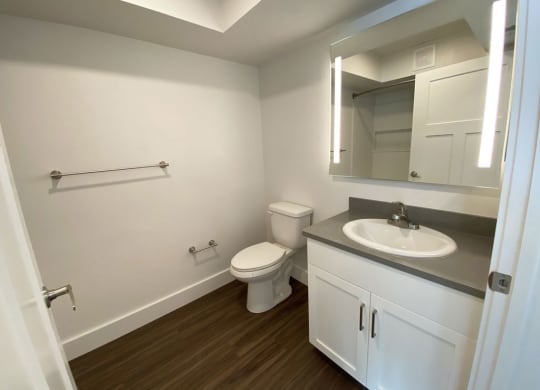 a bathroom with a white cabinetry and hard surface floors at Stoney Pointe Apartment Homes, Wichita, KS
