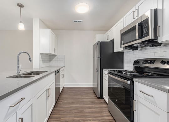 a kitchen with stainless steel appliances and white cabinets at Stoney Pointe Apartment Homes, Kansas, 67226