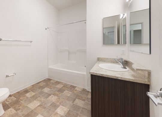 a bathroom with a toilet and a sink and a shower at Strathmore Apartment Homes, West Des Moines, 50266