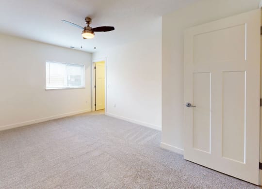 bedroom with ceiling fan and a door to a closet at Strathmore Apartment Homes, West Des Moines, 50266