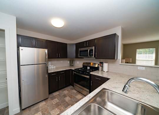 A kitchen with stainless steel appliances and a pantry at Strathmore Apartment Homes, West Des Moines, IA
