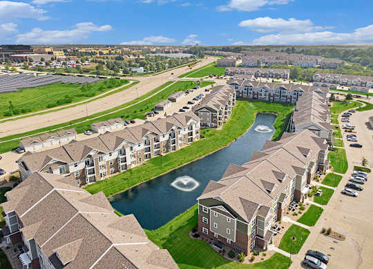 A large apartment community with a large pond running through it at Strathmore Apartment Homes, Iowa