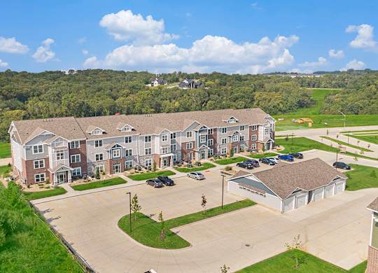 A large apartment complex with a parking lot and garages at Strathmore Apartment Homes, Iowa
