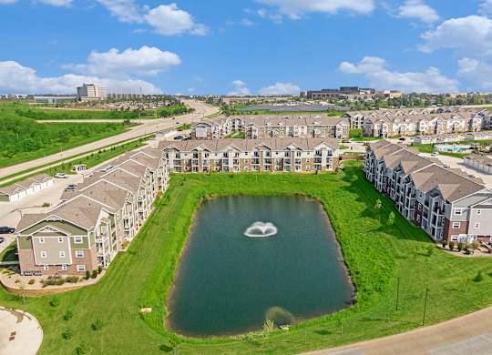 A large pond in the middle of an apartment community at Strathmore Apartment Homes, Iowa