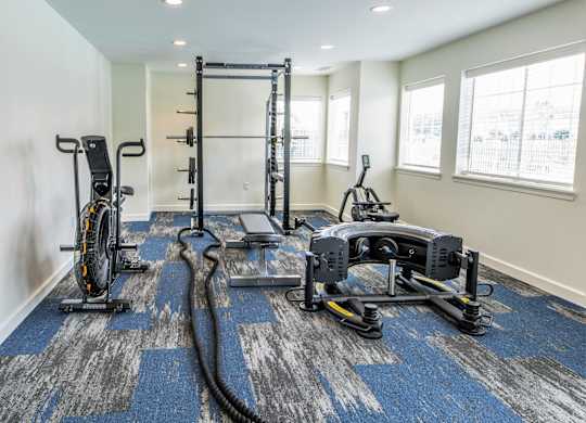 A home gym with a variety of equipment including a treadmill, rowing machine, and weights. at Sundance Apartments, Indiana, 46237