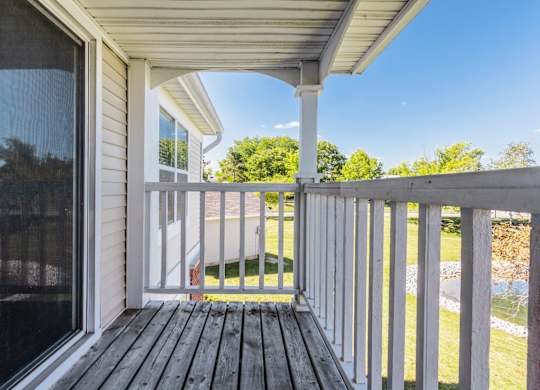 A porch with a white railing and a wooden floor. at Sundance Apartments, Indianapolis, Indiana