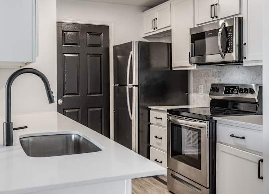 A modern kitchen with a black refrigerator and stove. at Sundance Apartments, Indianapolis, IN, 46237