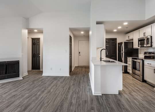 A modern kitchen with a white island and stainless steel appliances. at Sundance Apartments, Indianapolis, IN