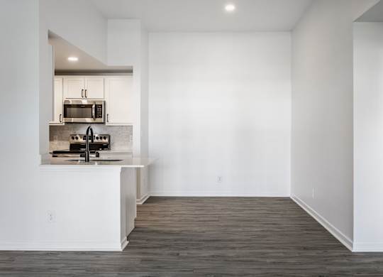 A kitchen with white walls and wooden floors. at Sundance Apartments, Indianapolis, 46237