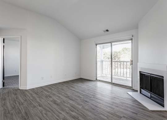 A room with a fireplace and sliding glass doors. at Sundance Apartments, Indiana