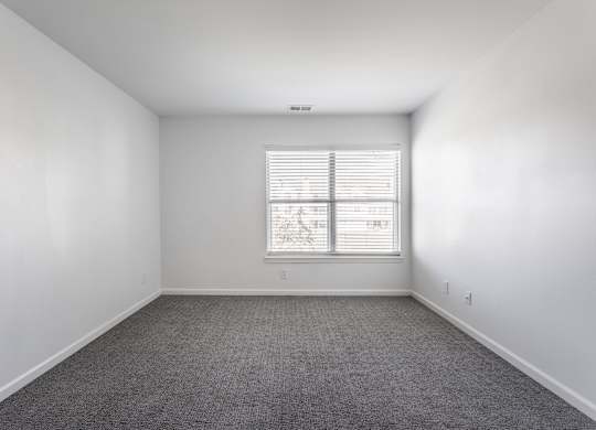 A room with a window and carpeted floor. at Sundance Apartments, Indianapolis