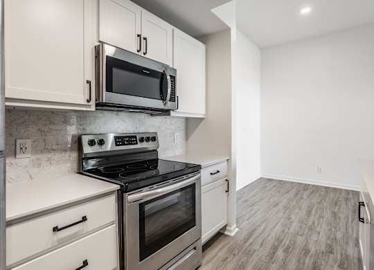 A kitchen with a stove top oven and microwave above it. at Sundance Apartments, Indianapolis, Indiana