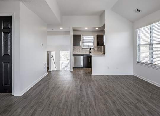 A spacious living room with a kitchen in the background. at Sundance Apartments, Indianapolis, Indiana