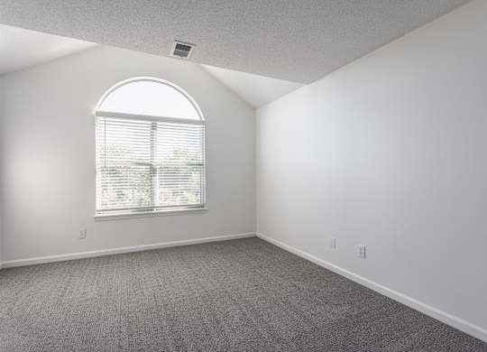 A room with a large window and carpeted floor. at Sundance Apartments, Indianapolis, IN
