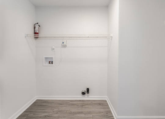 A white room with a fire extinguisher on the wall. at Sundance Apartments, Indiana, 46237
