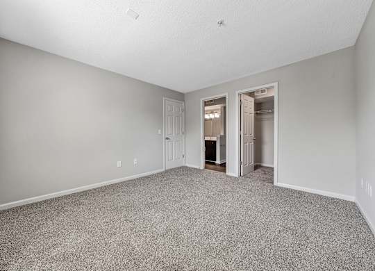 A spacious room with carpeted floor and two open doors. at Sunscape Apartments, Roanoke, Virginia