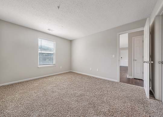 A room with a carpeted floor and a window with blinds. at Sunscape Apartments, Roanoke, Virginia