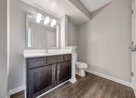 A bathroom with a white sink and a mirror above it. at Sunscape Apartments, Virginia