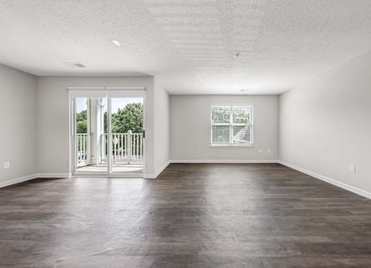 A large empty room with a sliding glass door. at Sunscape Apartments, Roanoke