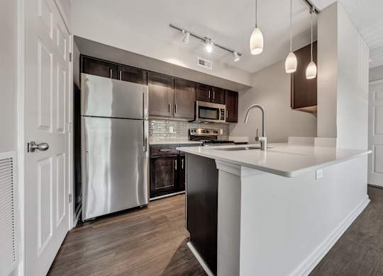 A modern kitchen with a refrigerator, microwave, and oven. at Sunscape Apartments, Roanoke, VA, 24018