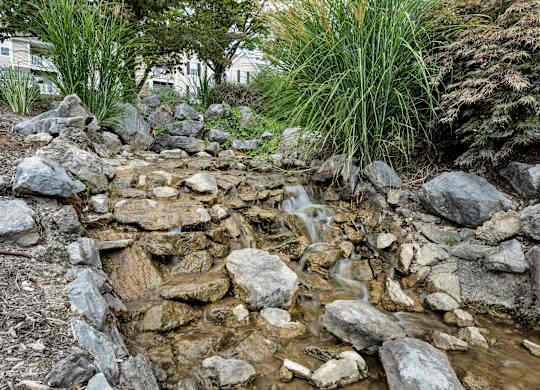 A small waterfall in a rock garden. at Sunscape Apartments, Roanoke, VA, 24018