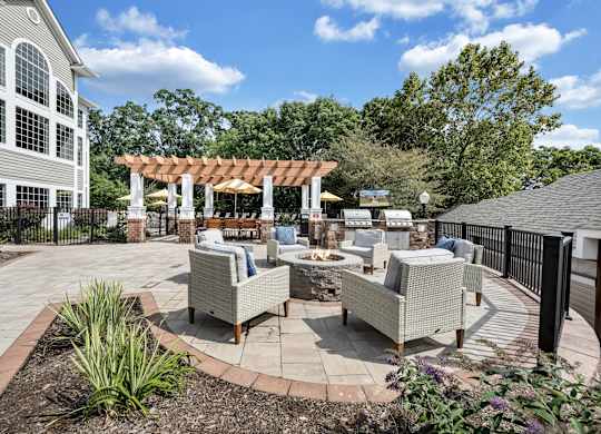 A patio area with a table and chairs is surrounded by a black fence. at Sunscape Apartments, Roanoke, VA, 24018