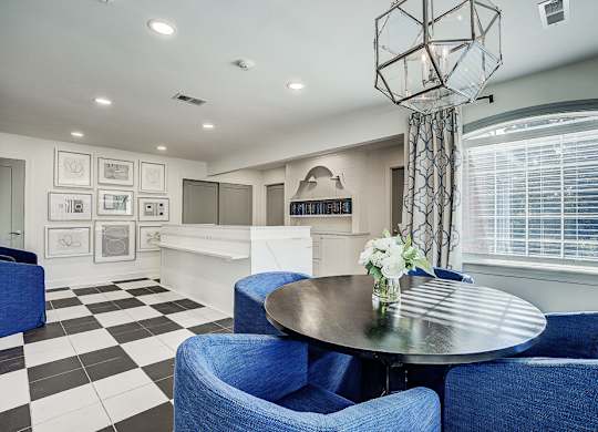 A black and white checkered floor in a room with blue chairs and a round table. at Sunscape Apartments, Roanoke, VA, 24018