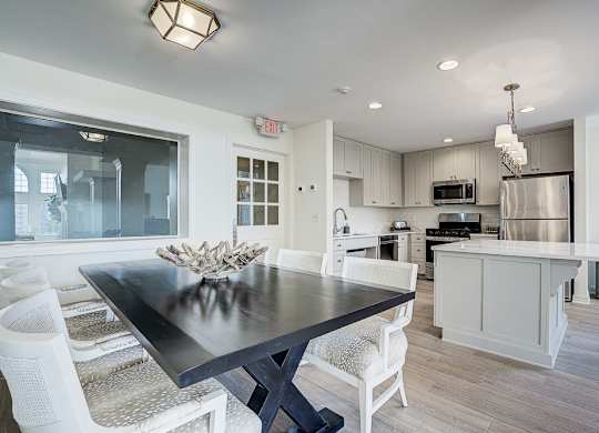 A modern kitchen with a dining table and chairs. at Sunscape Apartments, Roanoke, Virginia