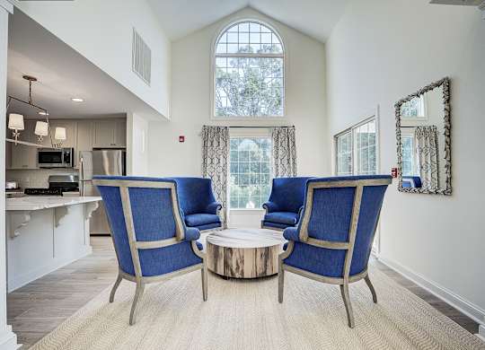 A living room with a blue chair and a coffee table. at Sunscape Apartments, Virginia, 24018