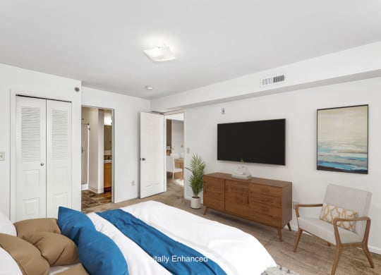a bedroom with a large bed and doors to a closet and bathroom at Tall Oaks Apartment Homes, Michigan