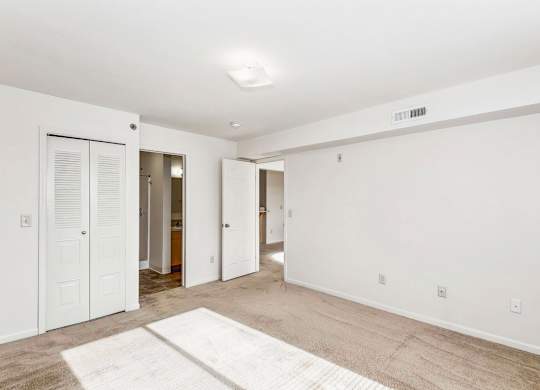 A spacious bedroom with an ensuite and a door to a walk-in closet at Tall Oaks Apartment Homes, Kalamazoo, MI, 49009