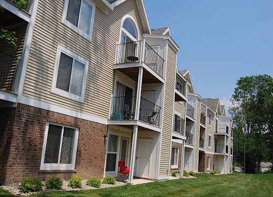 An exterior apartment building with private patios and balconies at Tall Oaks Apartment Homes, Kalamazoo, MI, 49009